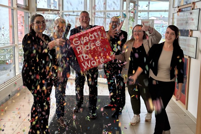 Mitarbeiter feiern mit Konfetti die Zertifizierung Great Place to Work 